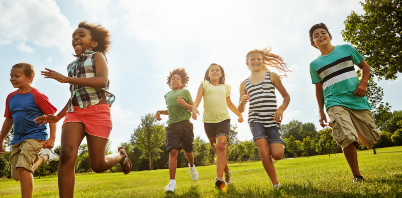 A group of children running around outside.