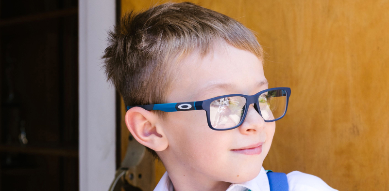 Child wearing blue Oakley kids' glasses