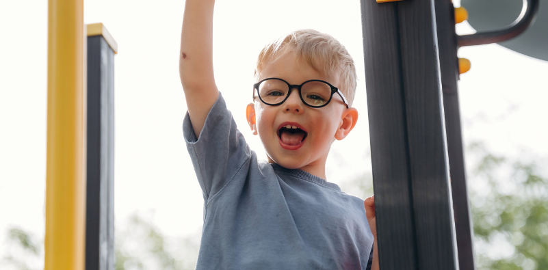 Child wearing kids' glasses while playing at a playground